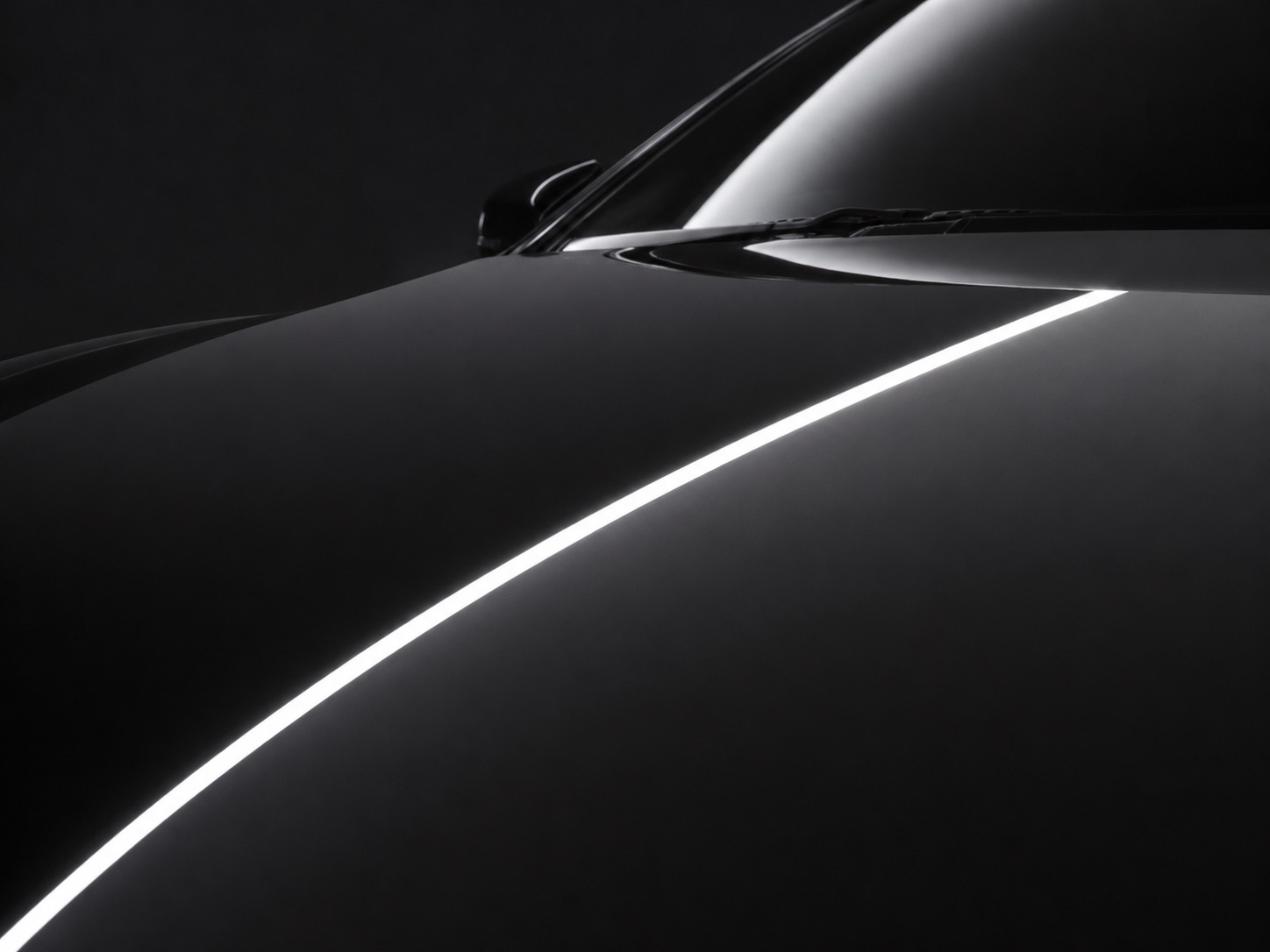 The same black hood from the same angle after correction, the strip light now reflected as one clean unbroken line